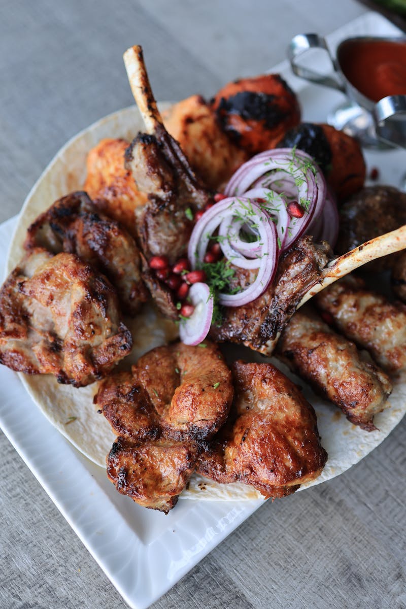 A mouthwatering assortment of grilled meats, served with onions and sauces. Perfect for dinner.