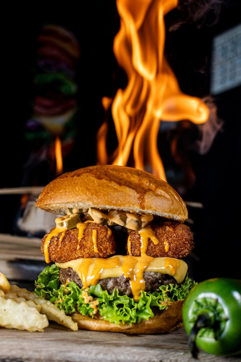 Delicious gourmet burger with jalapeño and fiery backdrop, showcasing spicy flavors and grilling perfection.