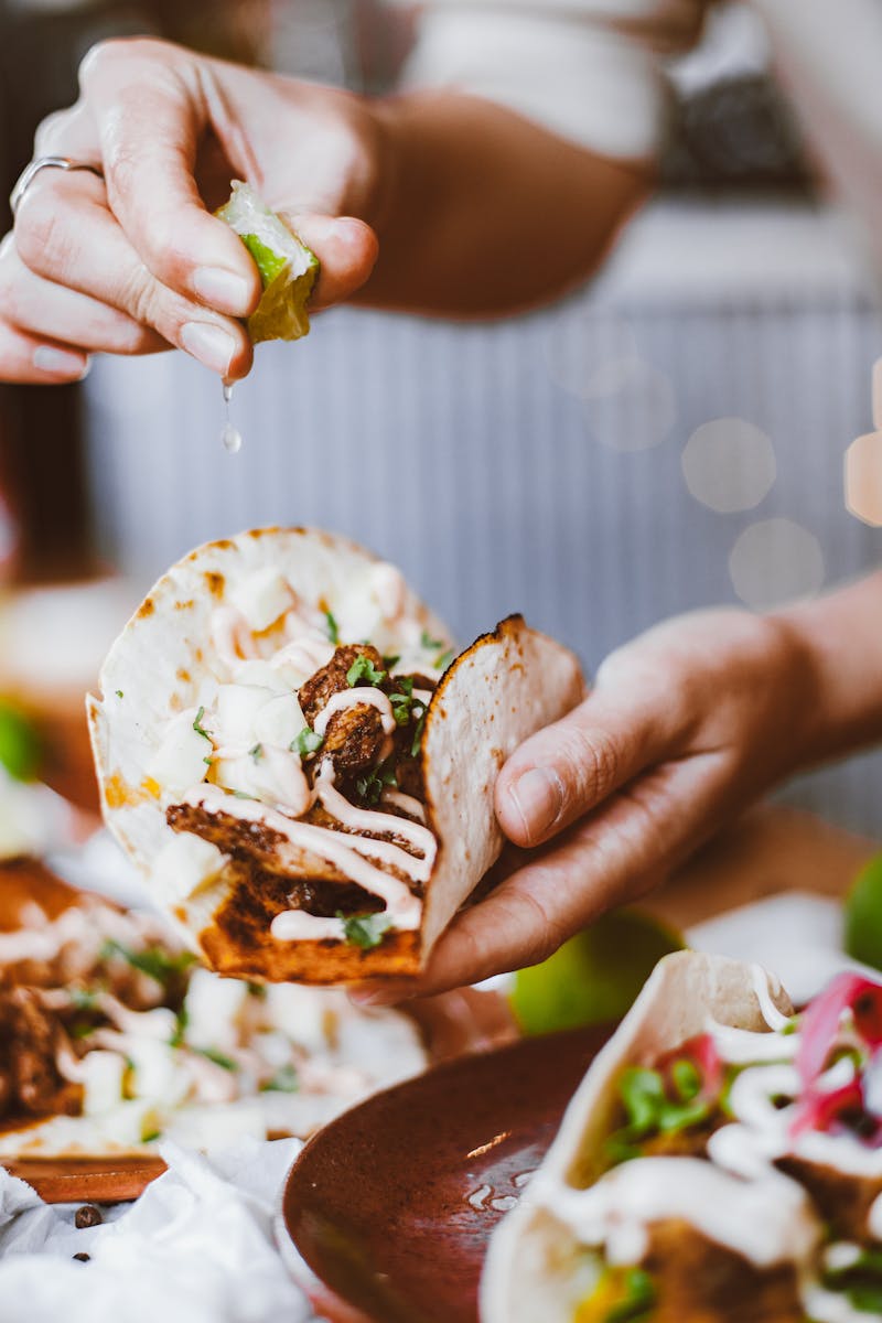 Closeup of gourmet tacos topped with lime juice for a fresh and zesty flavor.