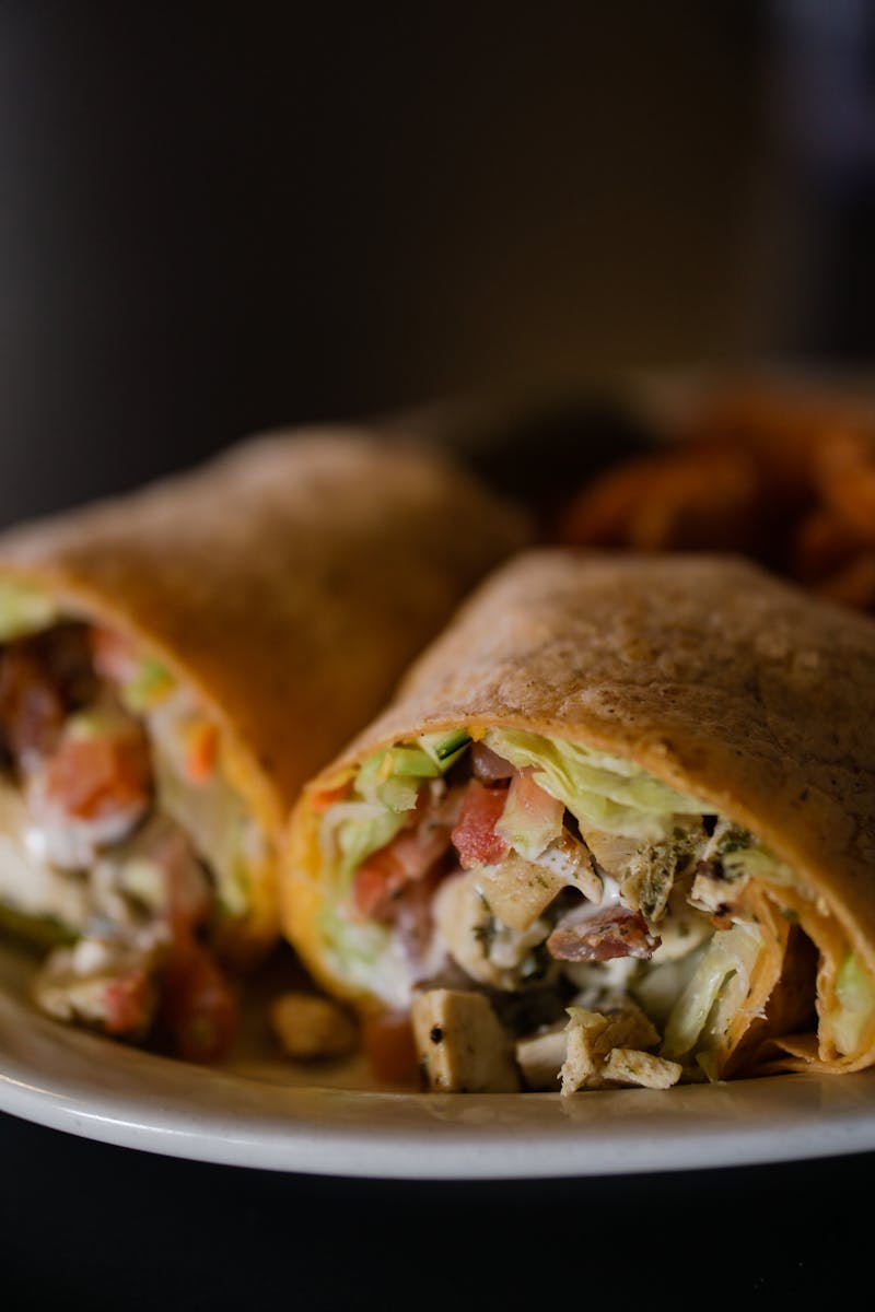 Savor this close-up of a delicious Mexican burrito wrap filled with fresh ingredients on a plate.