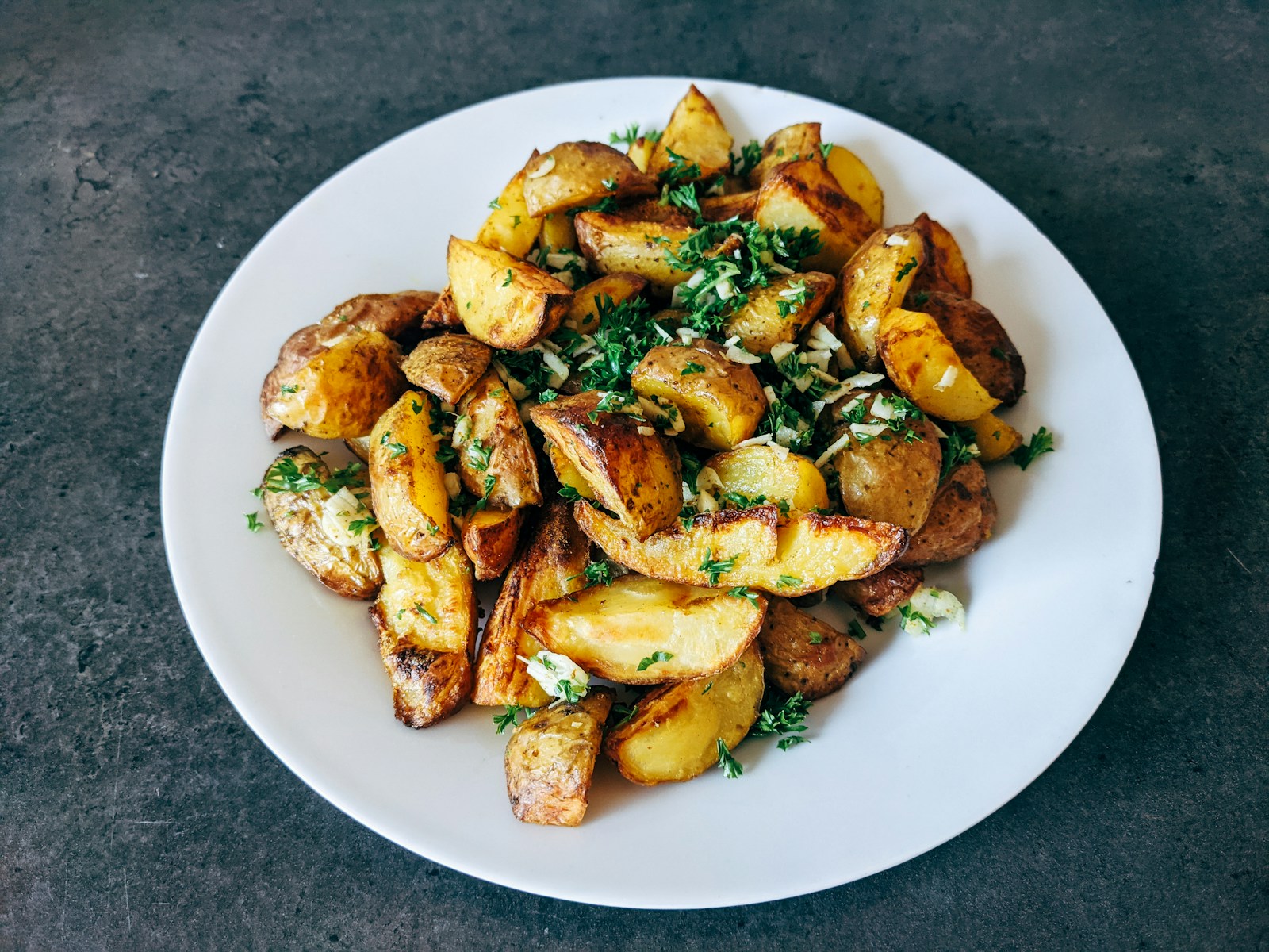 a white plate topped with potatoes and parsley