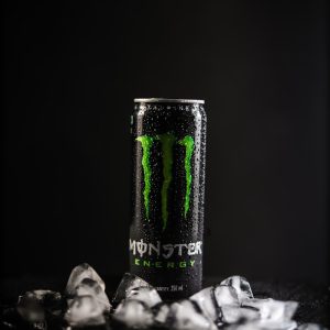 monster energy drink can on black and white textile