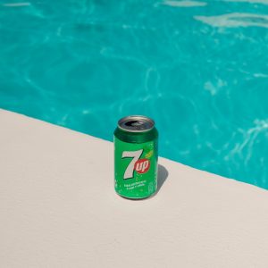 a can of 7up next to a swimming pool