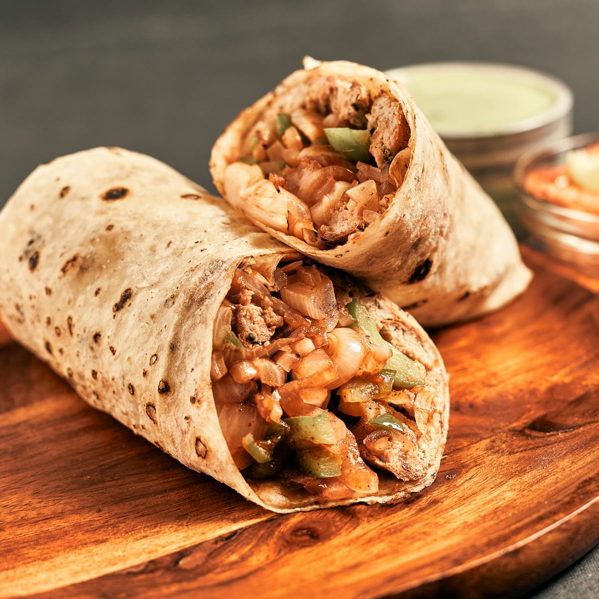 Appetizing Indian wrap filled with vegetables and spices, served on a wooden board.