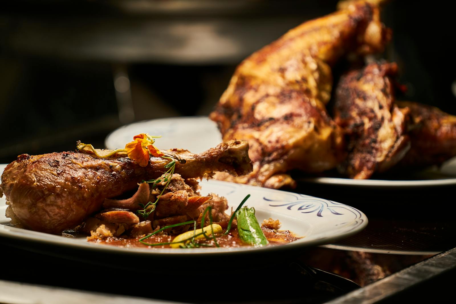 Close-up of a deliciously roasted chicken dish served with garnish, highlighting fine cuisine.