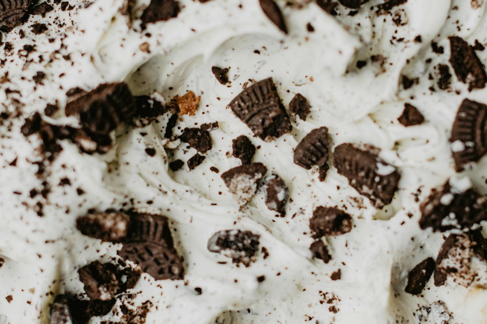 Close-up of creamy ice cream topped with chocolate cookie crumbles, a delightful dessert treat.