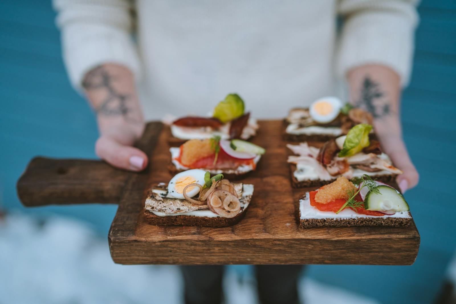 Delicious open-faced sandwiches with various toppings served on a wooden board, showcasing exquisite food styling.