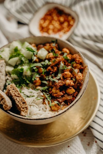 Savor a healthy vegan bowl featuring chickpeas, rice, cucumber, and herbs, perfect for dinner.