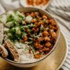 Savor a healthy vegan bowl featuring chickpeas, rice, cucumber, and herbs, perfect for dinner.