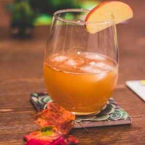 clear drinking glass with brown liquid and lemon