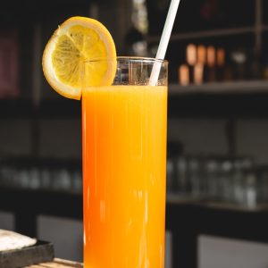 orange juice in clear drinking glass